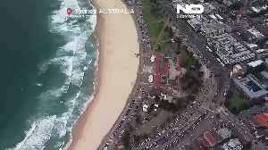 Hundreds gather to lay flowers at the site of the deadly Bondi Beach shooting