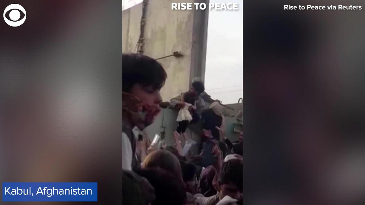 WEB EXTRA: Little Girl Lifted Over Wall at Kabul Airport