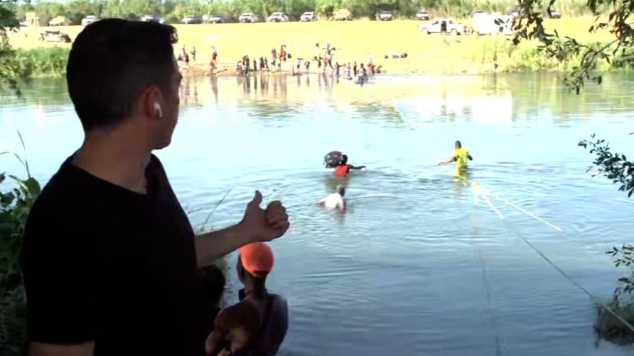 Migrants cross Rio Grande River during CNN reporter's liveshot