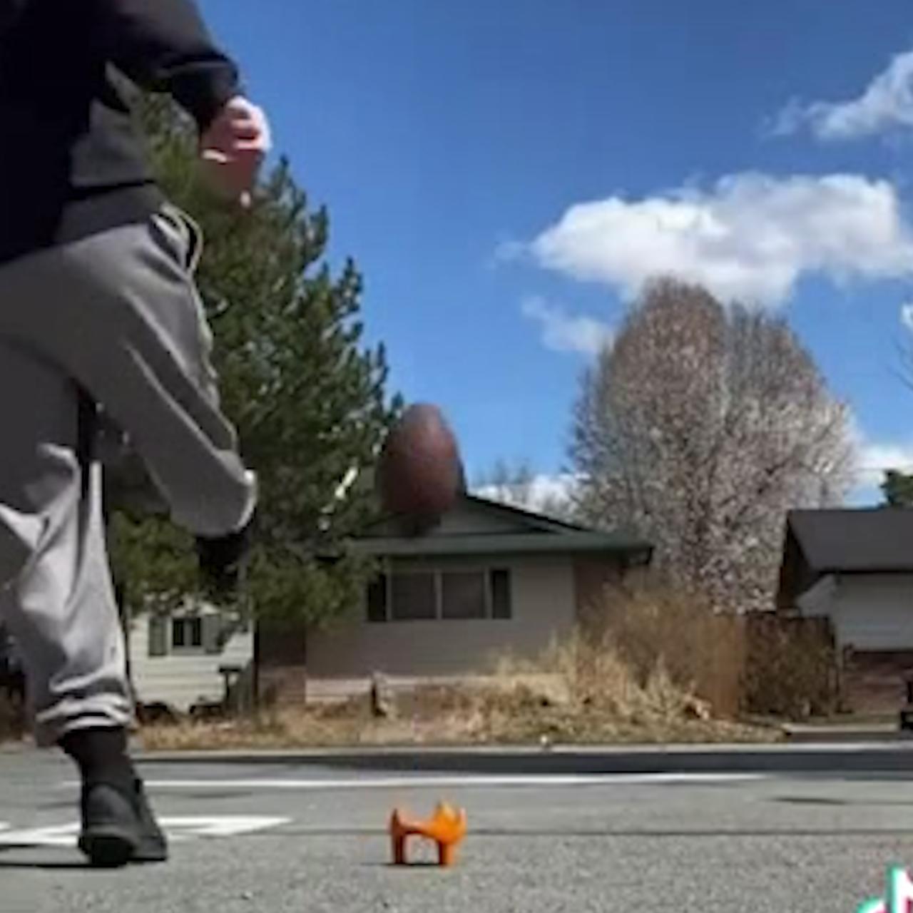Man kicks a football into a moving car multiple times