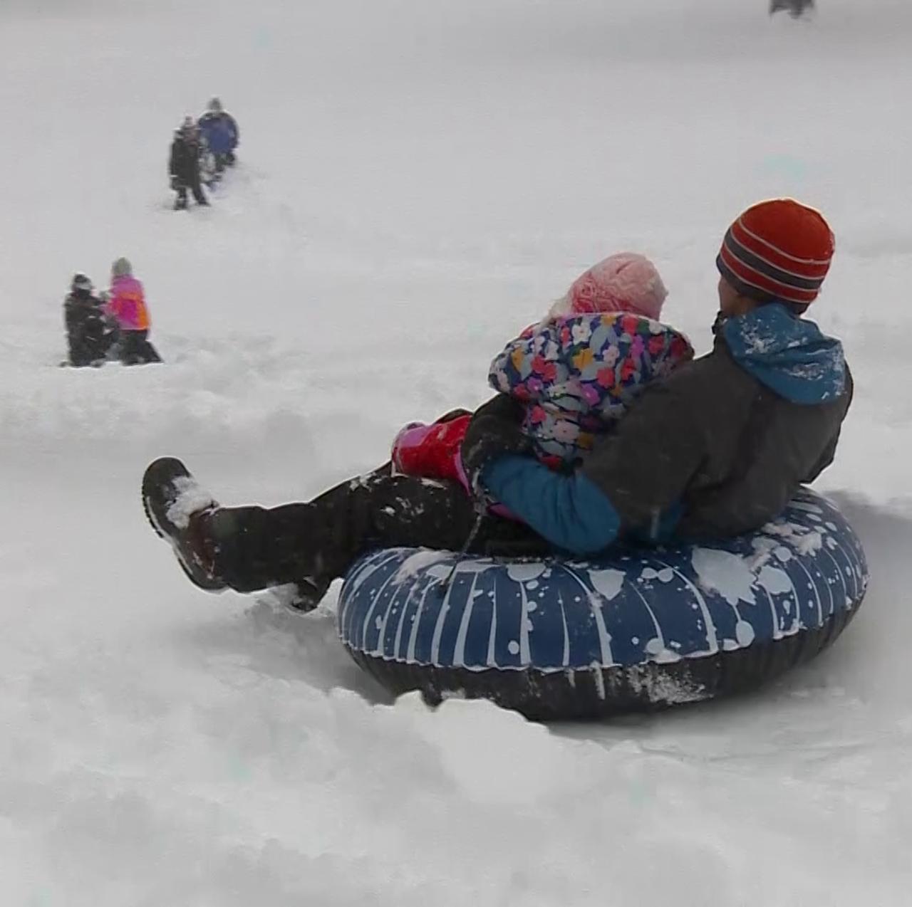 Families sledding in Westwood on snow day