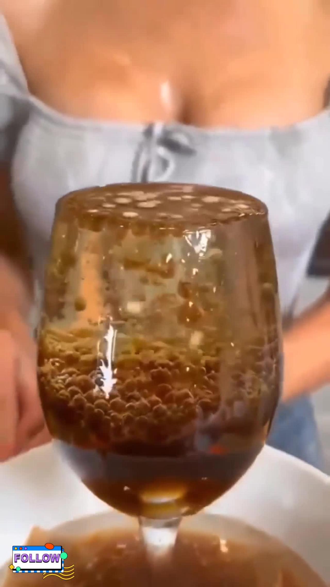 OMG She lifts the top glass to show what Coke and Mentos does in oil
