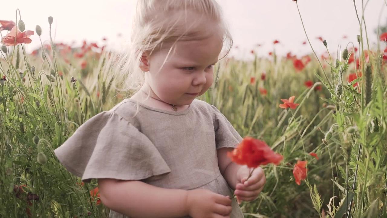 Little Girl Smelling Red Poppy Flower