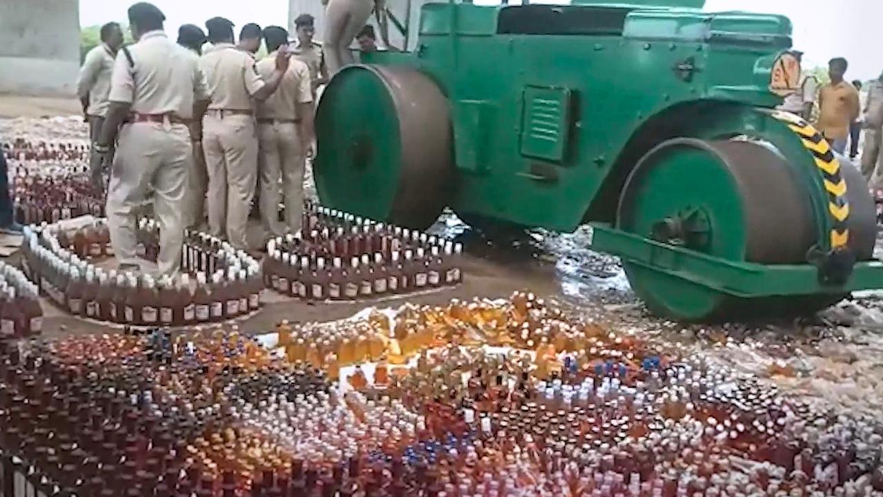 Police use steamroller to destroy thousands of smuggled liquor bottles
