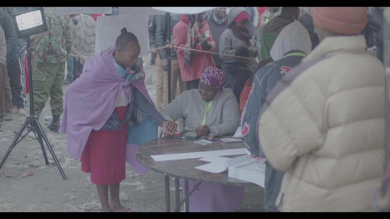 Kenyan Mother with Child on her back Collects her Ballot Papers in 2022 General Elections