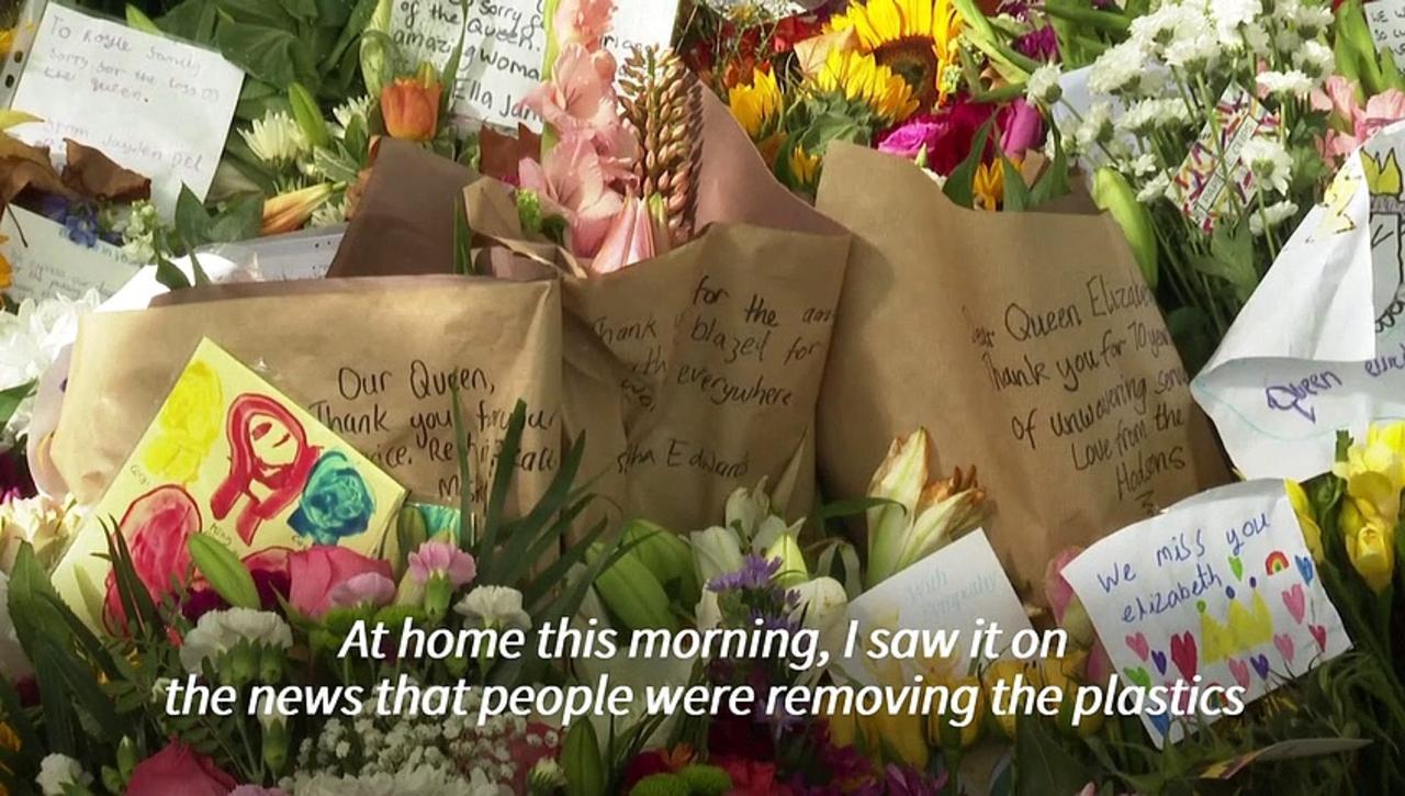 Volunteers in London remove plastic from flowers left for the queen