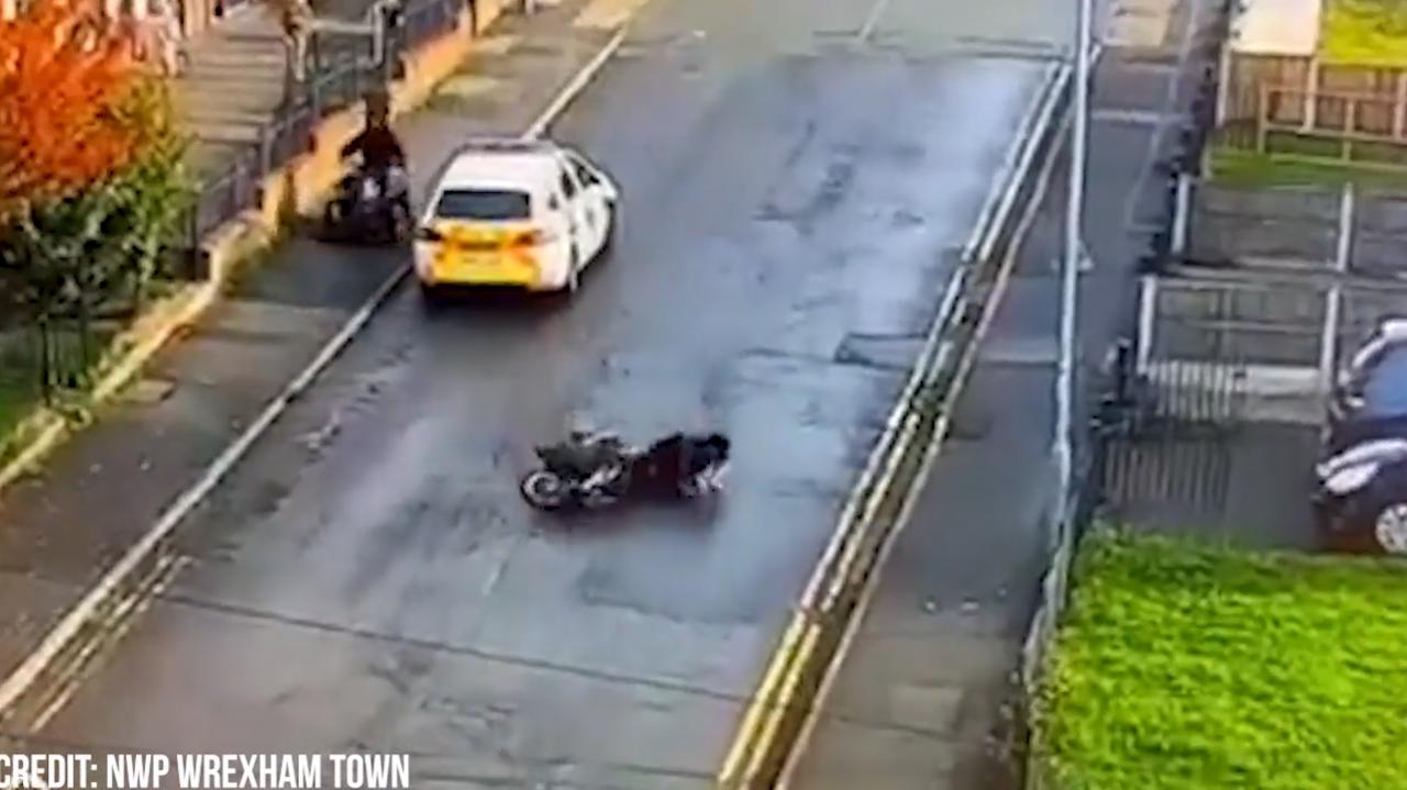 Moment hapless thug falls off scooter while trying to kick police car