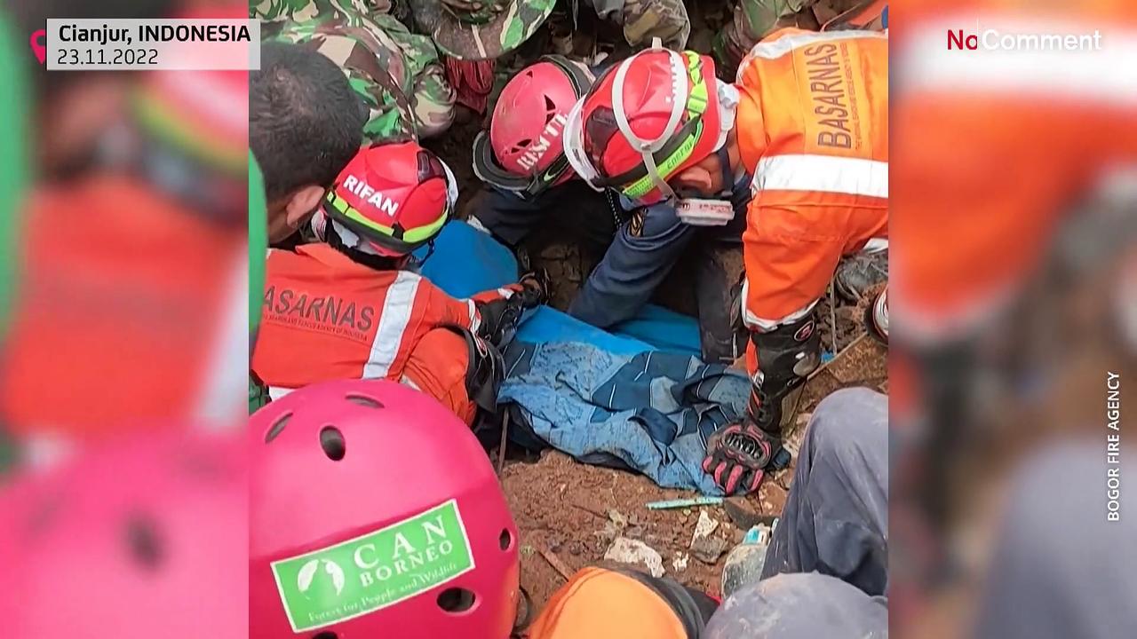 Rescuers in Indonesia pull a six-year-old boy from the rubble
