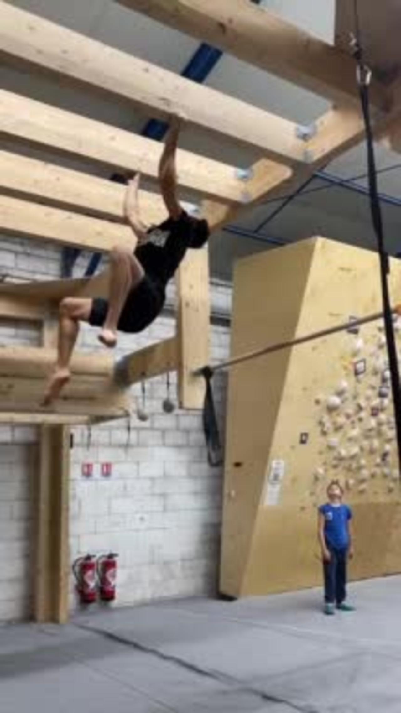 Guy Shows Strength by Gripping Wooden Ceiling Plank and Pulling His Body Towards it