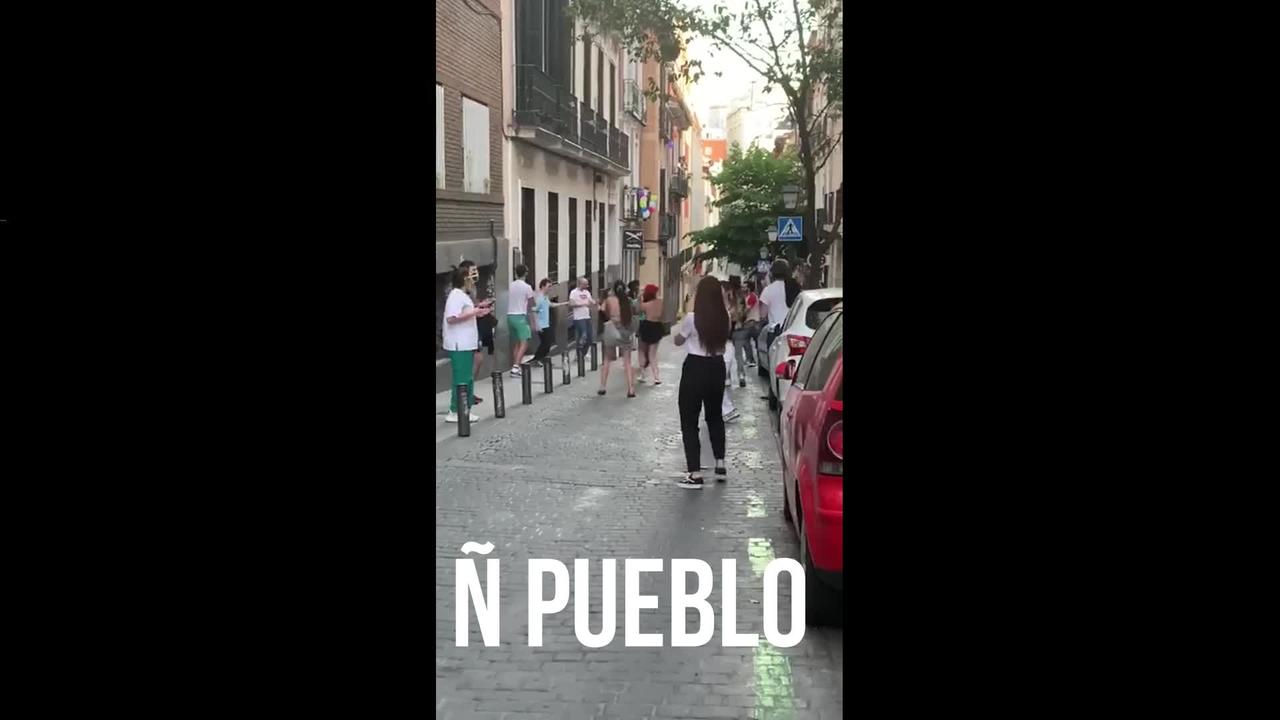 Varios jóvenes celebran con fiesta y desfile por la calle el fin de confinamiento en Madrid