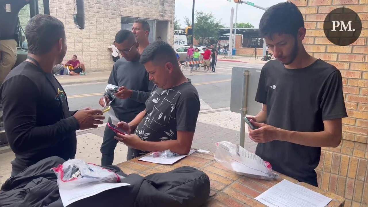 Brownsville, Texas: Migrants open their DHS packets.