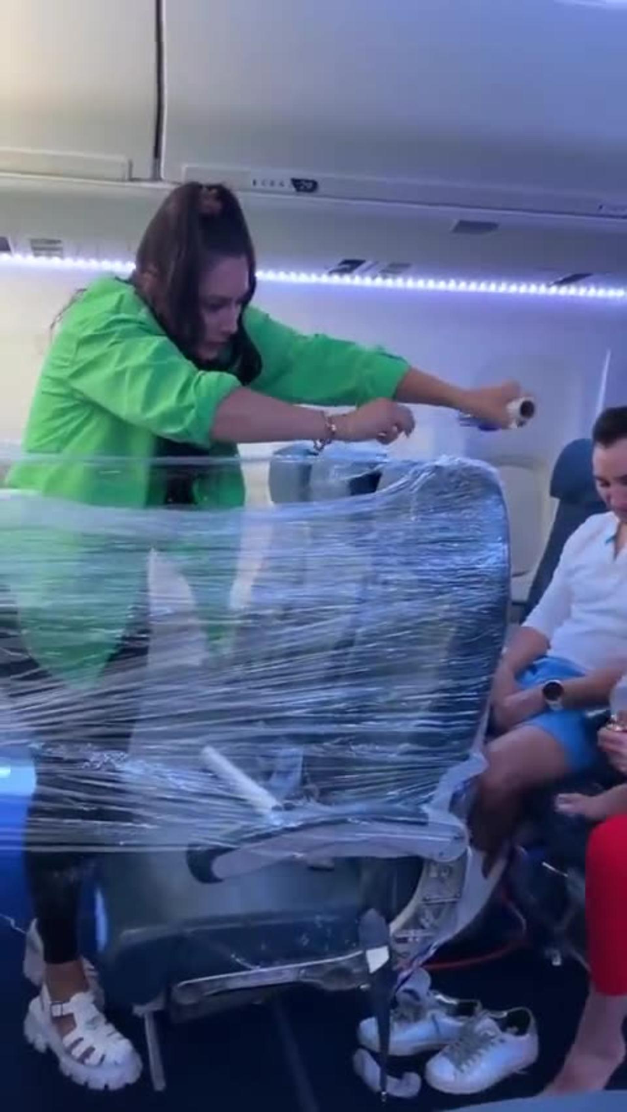crazy woman makes clingfilm fort on plane