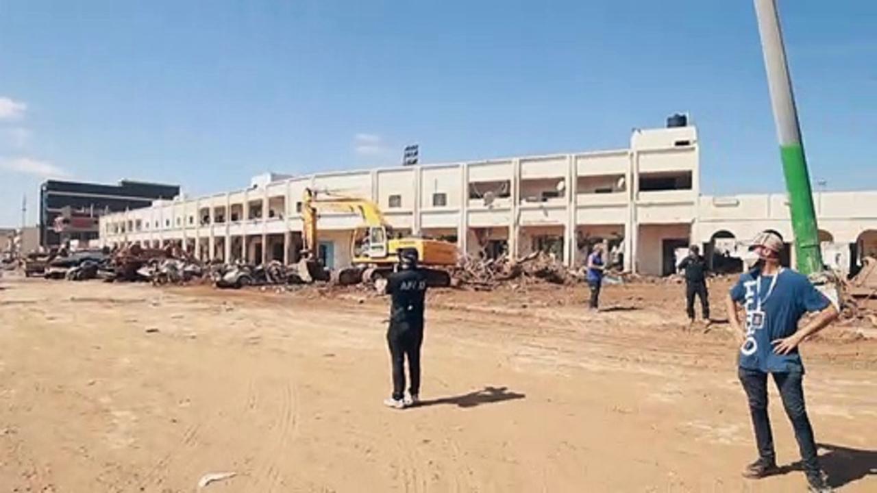 People walk amid rubble in Libya's flood-hit Derna