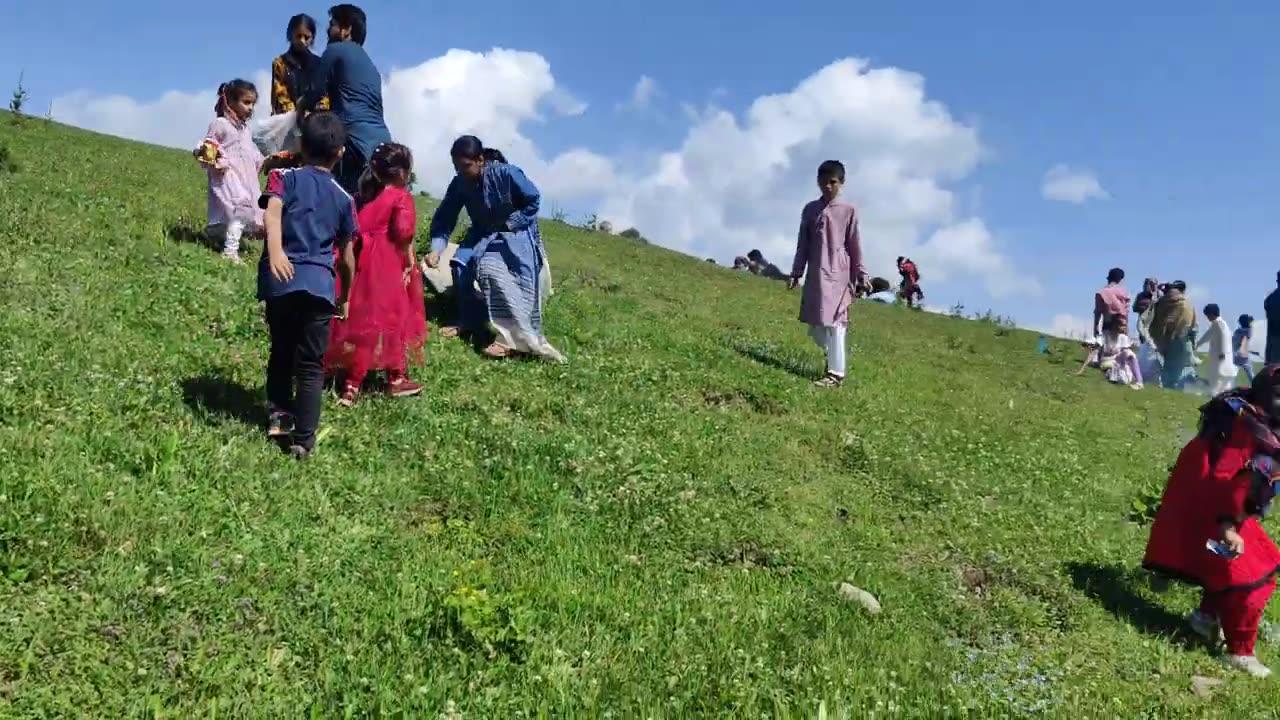What are these children like flowers collecting in the beautiful mountains of Azad Kashmir?Tourists
