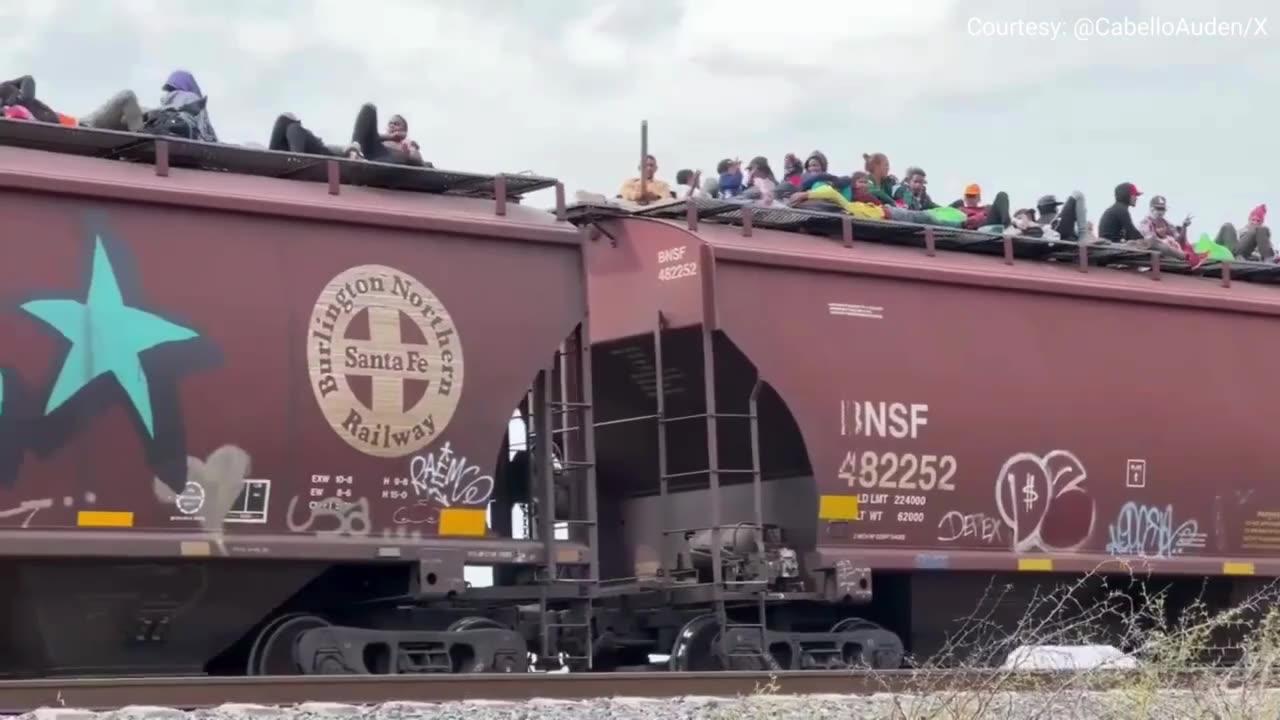 Train in Mexico packed full of migrants riding on top barrels toward US southern border