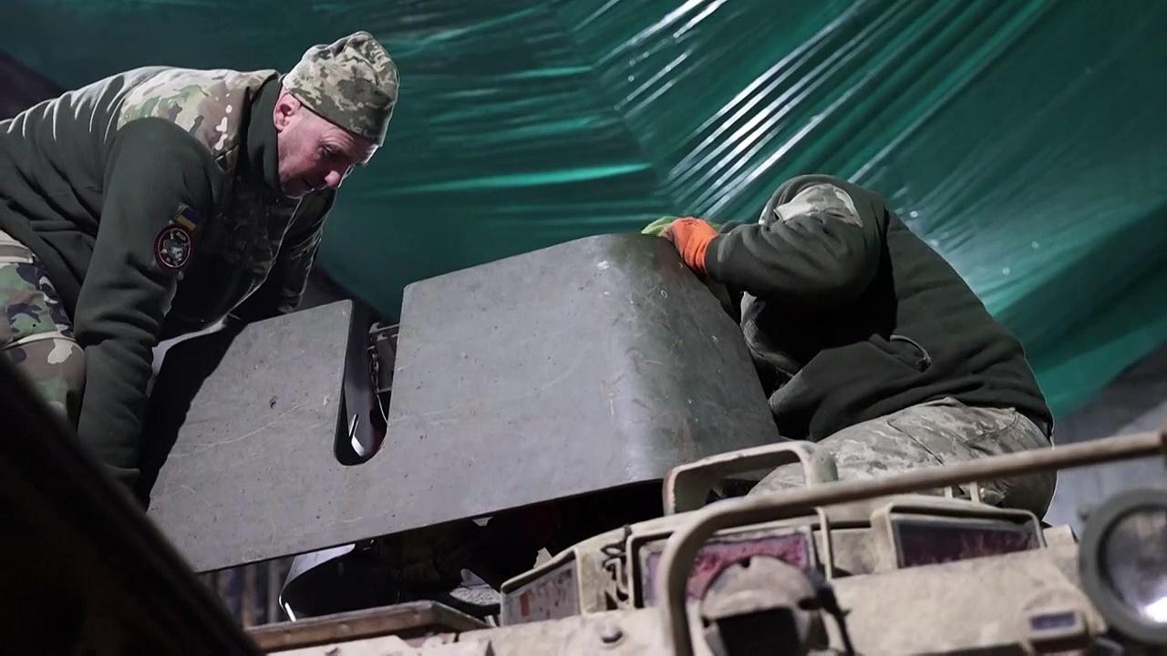Ukrainian servicemen repair weapons near the front line