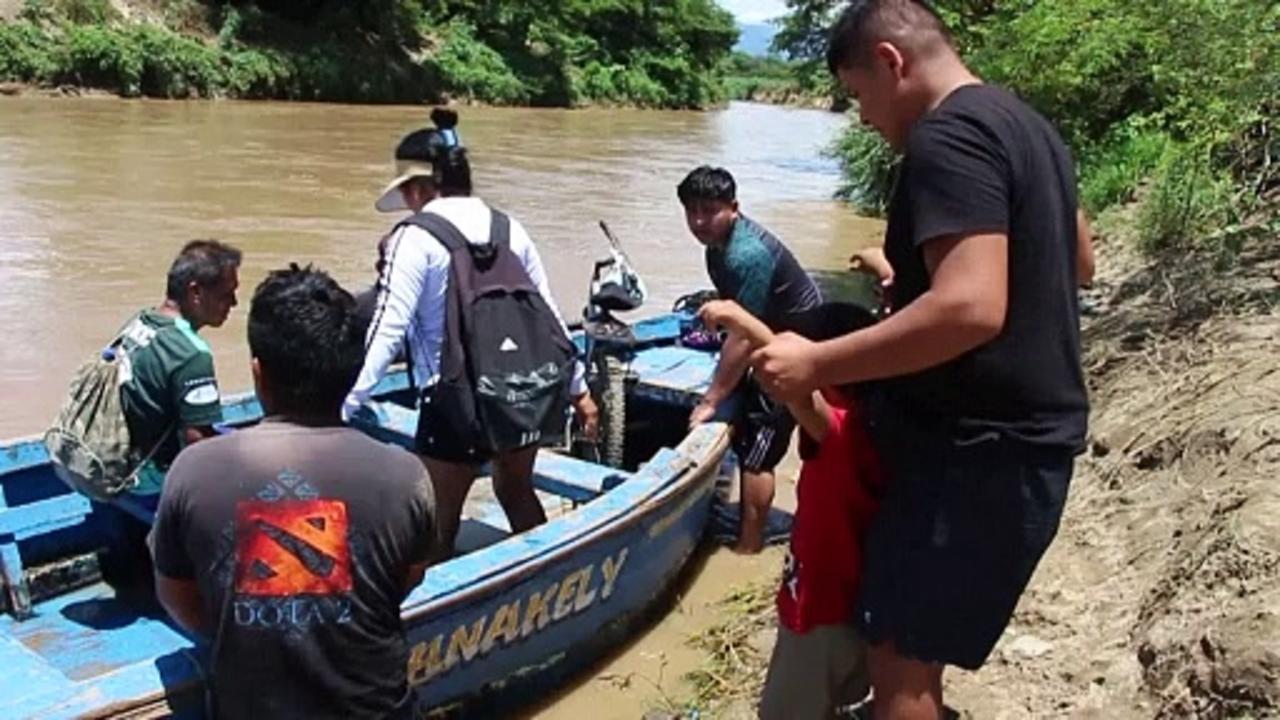Peruvians struggle to cross river flooded by rains