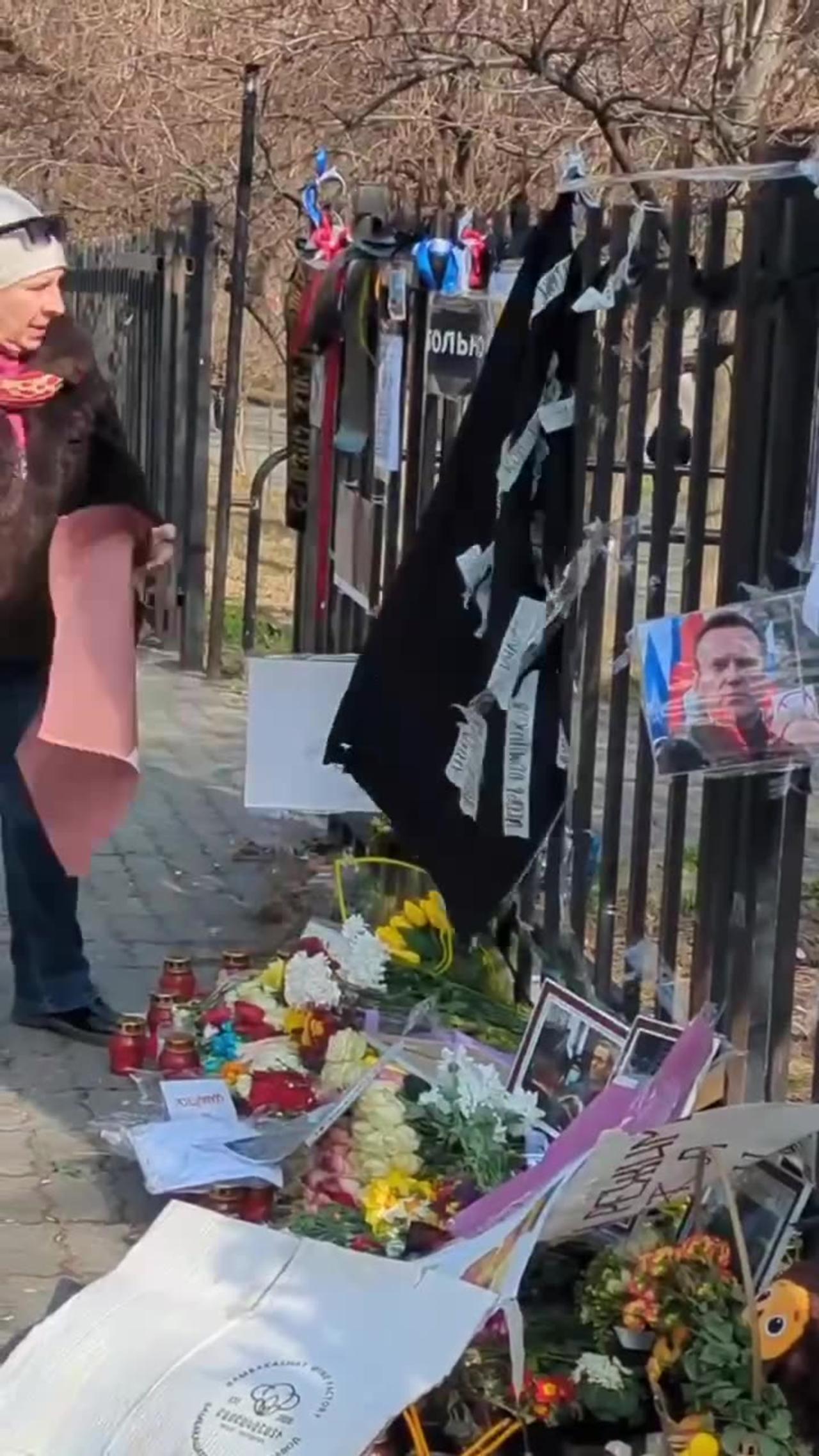 A woman destroys a temporary memorial for... Alexey Navalny