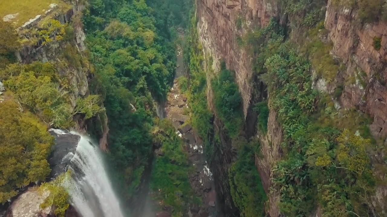 Water cascades down  a rugged cliff