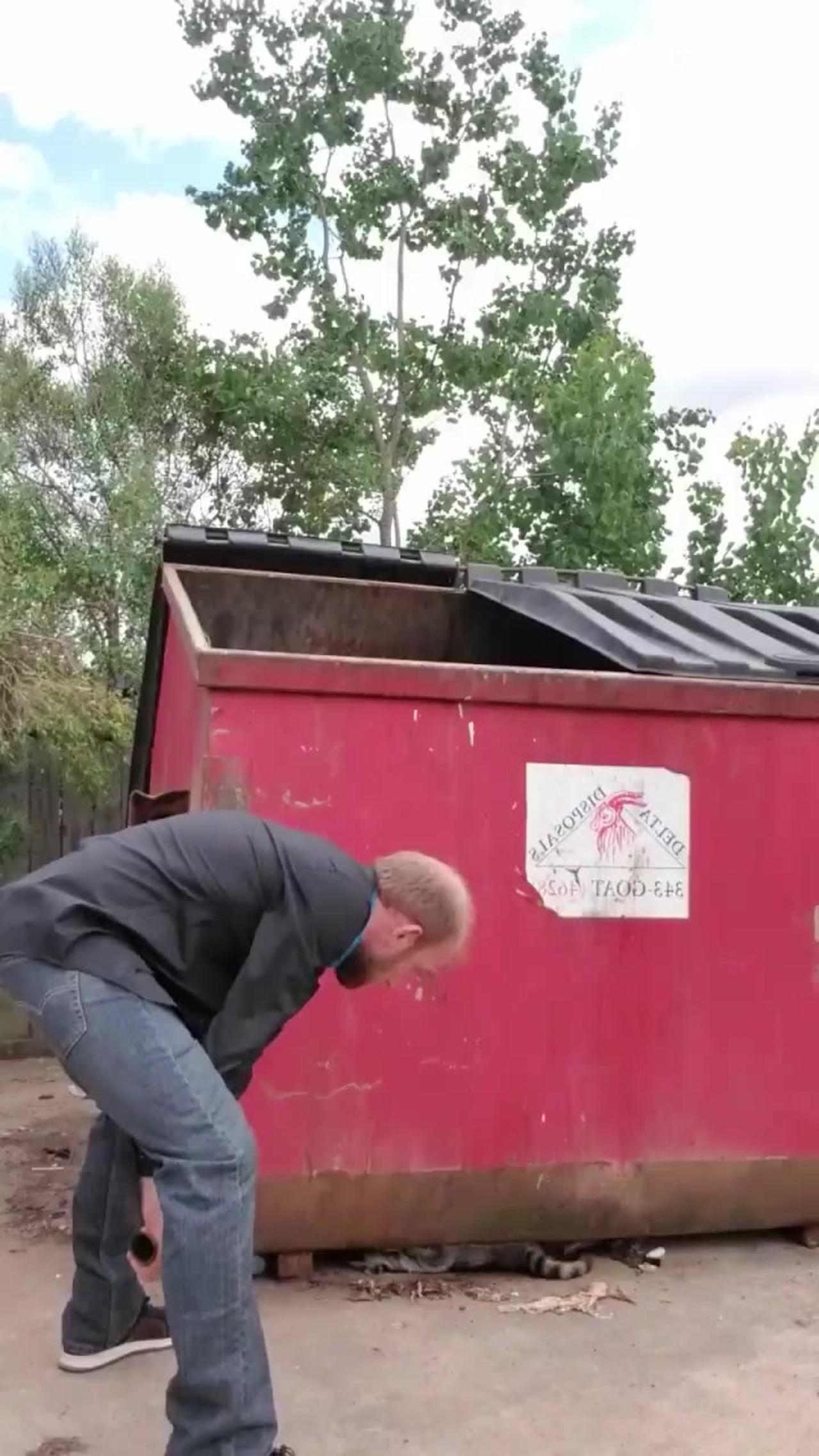Man Helps Raccoon Stuck Under Dumpster