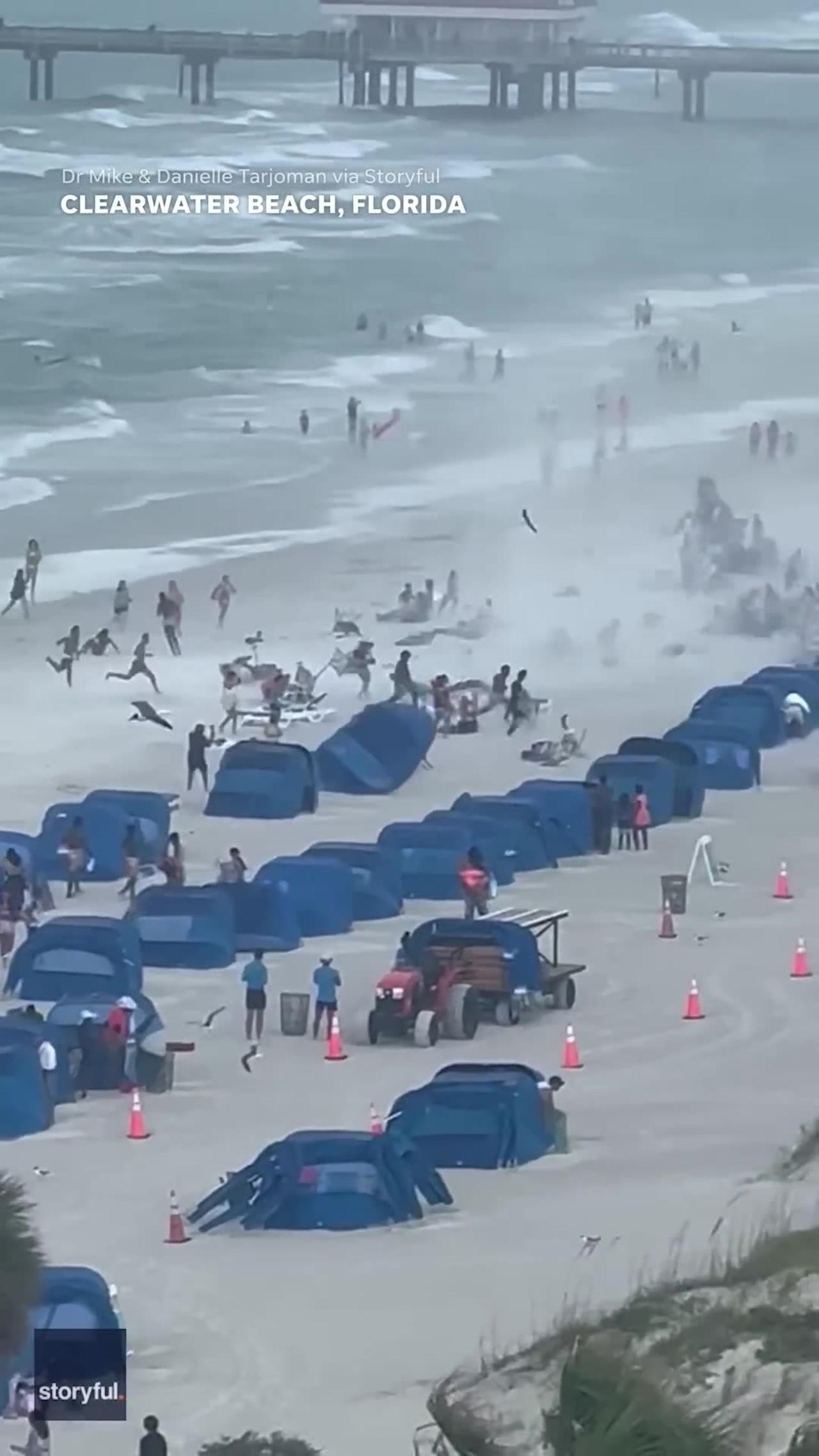 Stunning footage captures a massive waterspout tearing through a crowded beach