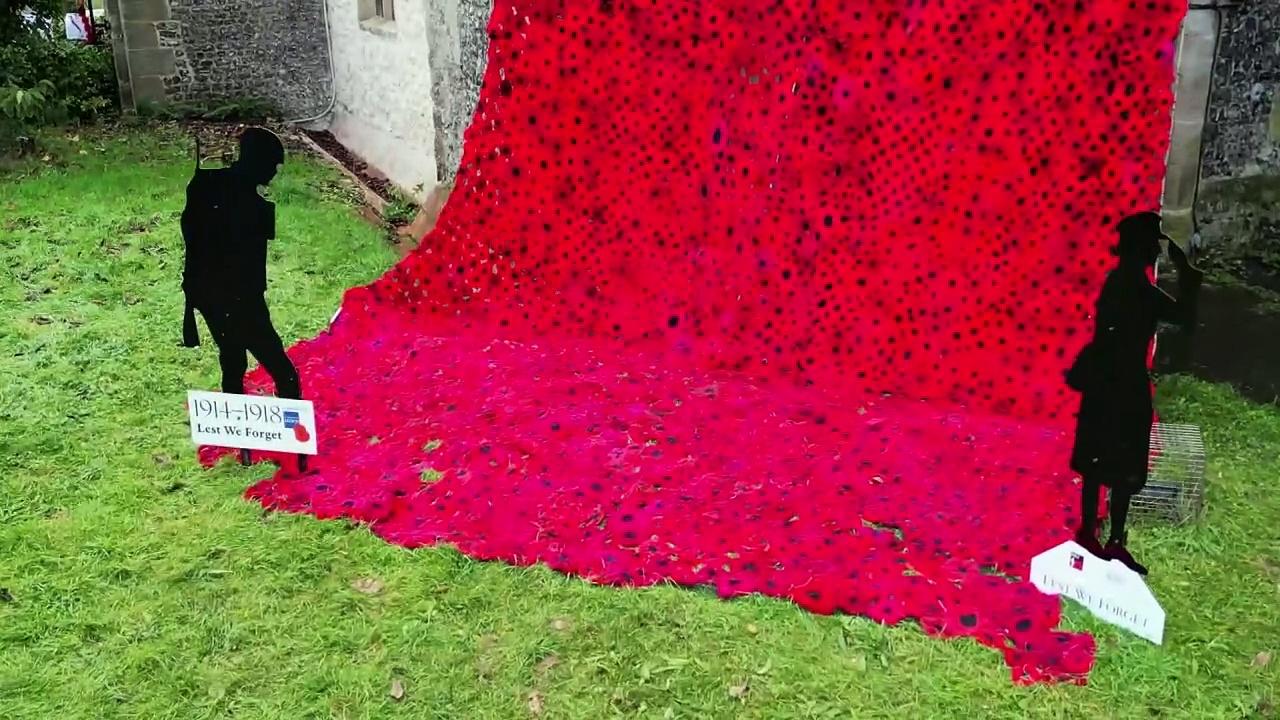 Thousands of knitted poppies cascade in remembrance tribute