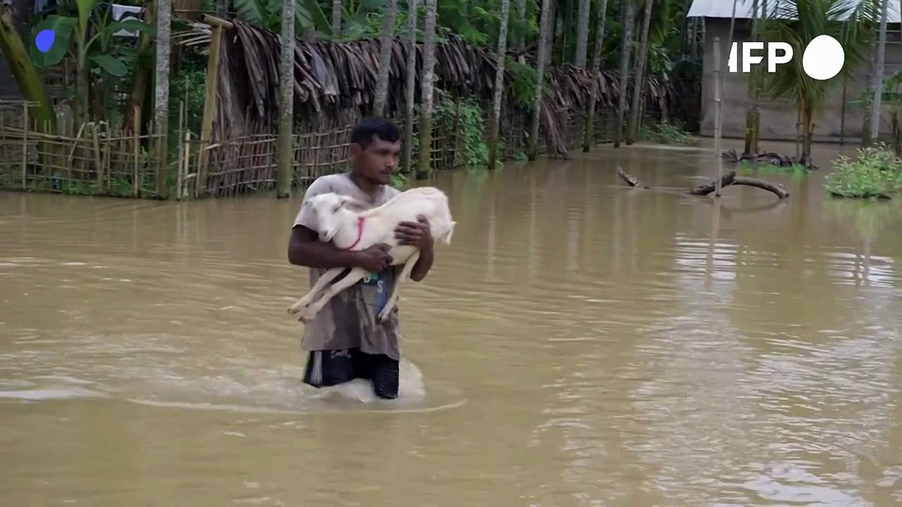 Locals wade through water after monsoon rains in northeast India leave dozens dead